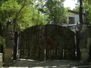 iki muhteşem kahraman ormanın içinde büyük bir beyaz modern ev için önde gelen bir dövme fantezi desenli büyük ahşap kapı tarafından korunan vardır. geri kalanını yerleştirin ve seyahat