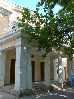 Büyük beyaz sütunlar ve sütun ile bina sarı girişinde önde gelen adımları