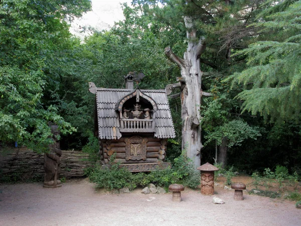 Ozdobny drewniany dom z tarasem i niedźwiedzia rzeźby w parku — Zdjęcie stockowe