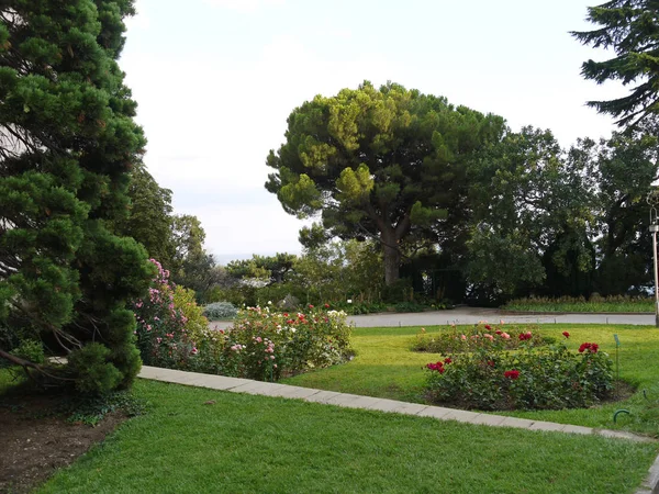 Park för avkoppling med färska gröna gräsmattor och blomsterrabatter med blommor — Stockfoto