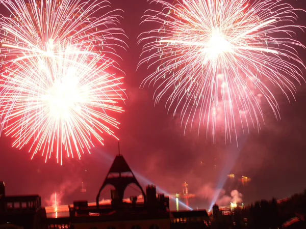 Parlak renkli, belirsiz yarı-defne selamlıyor tatili. Akşam şehir siluetleri arka planı.
