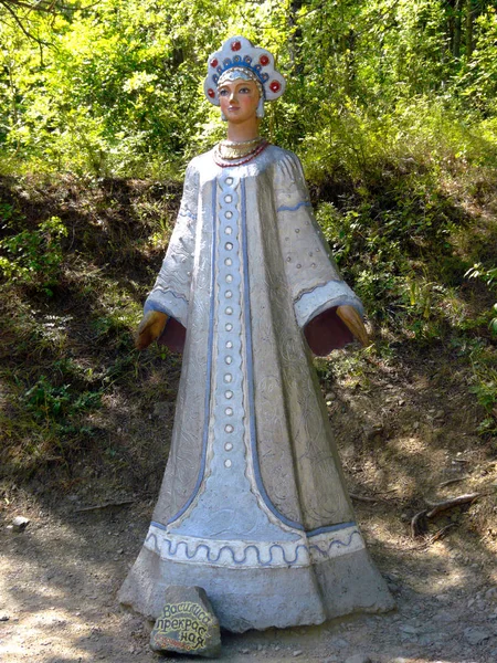 Heykel masal karakteri Vasilisa güzel yeşil yaprak döken ağaçlar arka planı