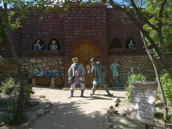 Muro de ladrillo del castillo con una puerta y estatuas en el parque para los turistas —  Fotos de Stock