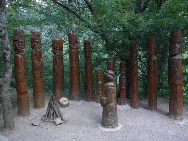 12 ヶ月と森に前肢に来た女の子の木製の彫刻の展示 — ストック写真