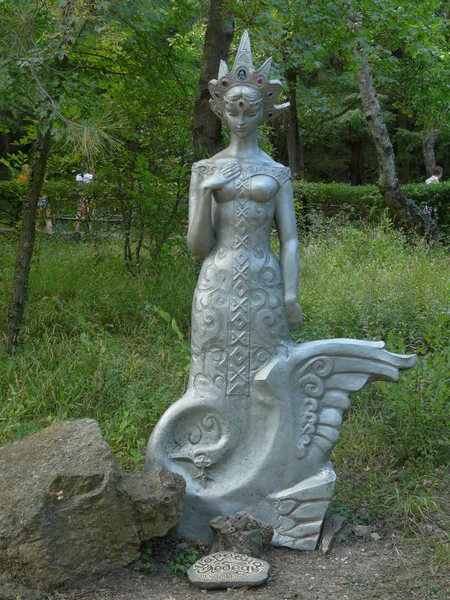 Sculpture en pierre de l'héroïne des contes de fées de la Princesse Cygne sur fond de parc verdoyant — Photo