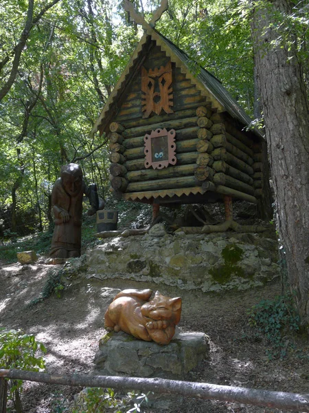 Bir kulübe tavuk budu üzerinde arka plan üzerinde bir turuncu kedi ve Baba Yaga heykeller