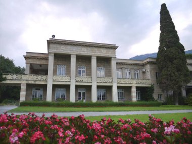 yanında güzel çiçek çiçek açan çiçek yatak ile basit bir tarzda inşa edilmiş iki katlı bir evde