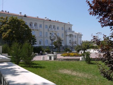 güzel bir ev ayakta arkasında gölgesi bir parkta bankta oturan adam