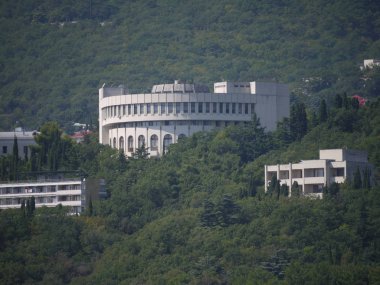Eski sanatoryum uzun yeşil ağaçların gölgesinde karmaşık güzel yarı dairesel yapının doğal görünümünü