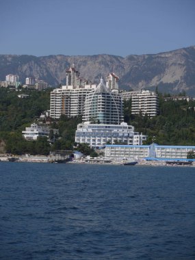 Çok sayıda otel ve tatil evleri büyük rocky Dağları arka planı ile kıyı deniz alanı