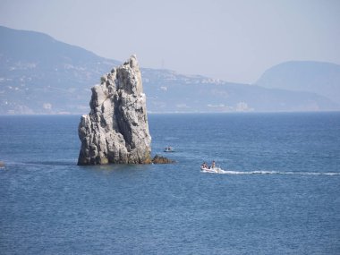 bulutlu, uzak kıyı şeridi fon karşı denizde uzun boylu bir kayalık promontory