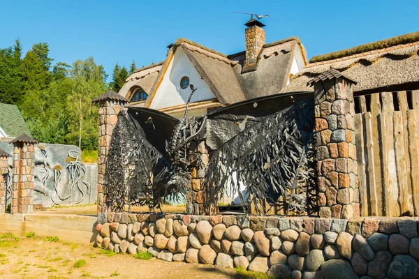 En mycket intressant Smidda staket på sten stiftelser nära en vass tak house — Stockfoto
