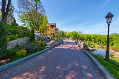 bir yolu bir ahşap evin yakınındaki nehrin bir köprü ile donanımlı bir Parkı