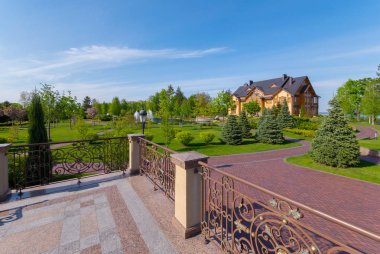 Yeşil ağaç ve taş sokaklar park yakınındaki güzel, ferforje küpeşte ile görüntüleme platformu