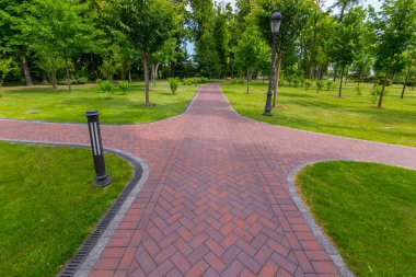 Sorunsuz kesip çimenler ve yeşil ağaçları ile kaplı bir kırmızı renkli sokak