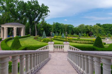Tepeli yeşil çalılar ve çardak ile park sokak inip