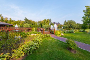 Yeşil doğanın bir parkta güzel bir manzara ile bahçenizi güzel çimenler çeşmeler ağaçlar yeşillik sarılık ile arka planı temiz su ile.