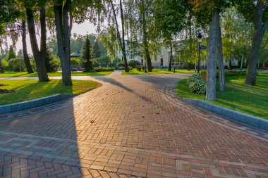 Arka planı yeşil park bölgesi döşenmiş geniş sokakları