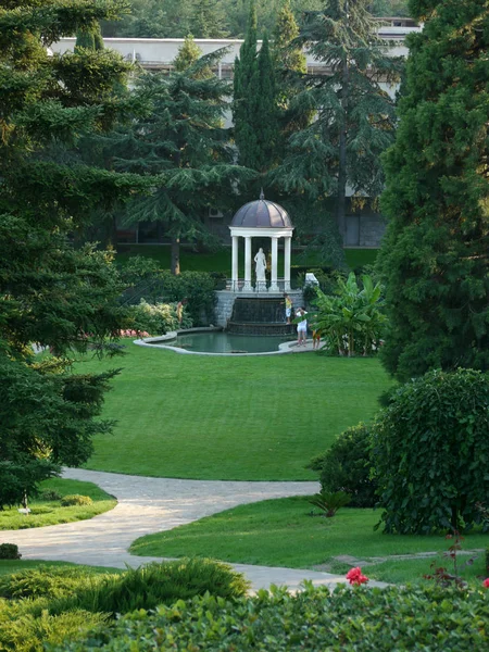 Estatua de monumento bajo la cúpula cerca del lago en un parque verde y limpio — Foto de Stock