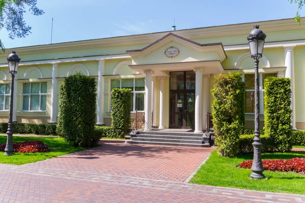 Straße mit zwei Laternen und hohen dekorativen Büschen auf dem Hintergrund eines schönen Hauses — Stockfoto