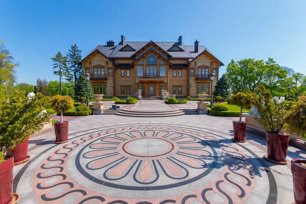 Une belle place devant la maison avec des motifs floraux et des fleurs-arbres dans les cavaliers autour — Photo