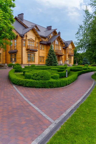 Hermoso patio limpio con arbustos de boj recortados en frente de una gran casa de madera. Mezhygirya Kiev, Ucrania — Foto de Stock