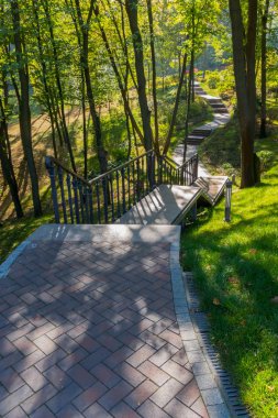 Siyah bir metal çit ve fenerler arka planı yeşil park bölgesinin her tarafında basamaklı taşlarla