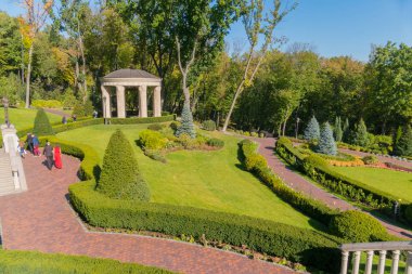 Güzel insan insanlar iyi bir ruh halinde istirahat pistlerde yürüme ile peyzaj çim tepeden parka görünümünde.