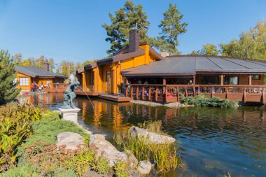 Park bölgesi heykeller ile arka planda göl kenarında ahşap Restoran