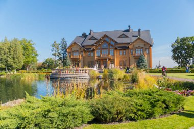 Dekoratif bir göl arka planda büyük bir ahşap villa yakınındaki bir görüntüleme platformu