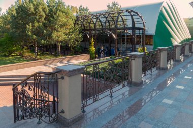 Bir görünümden bir eğri metal çit ve insanlar sokak girişinde önünde duran aşağıda bir mermer merdiven