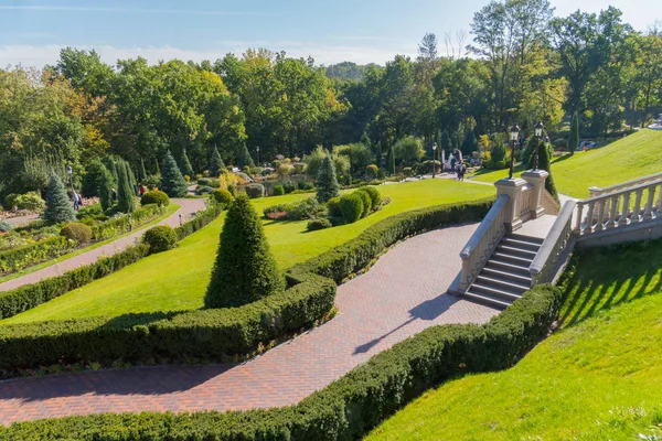 Un paisaje pintoresco de un parque verde situado en las laderas con caminos de escaleras y una flora diversa — Foto de Stock