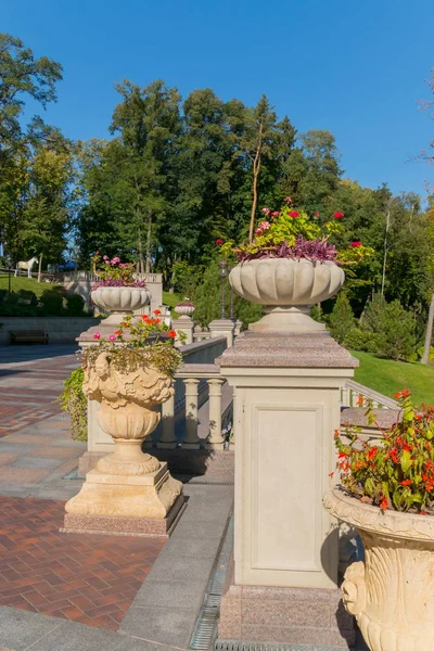 Blumenbeete auf Säulen in den Schalen am Geländer auf dem Platz im Park — Stockfoto