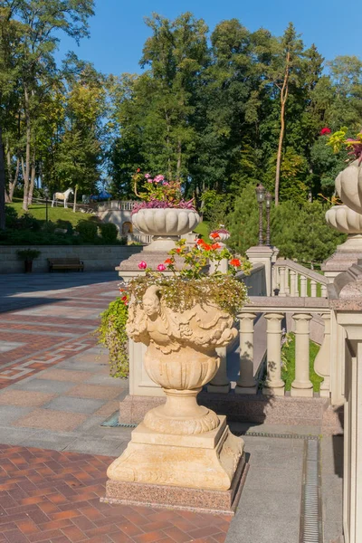 Macizos de flores de piedra decorativos, decorados con esculturas de estuco en el fondo de la zona verde del parque — Foto de Stock