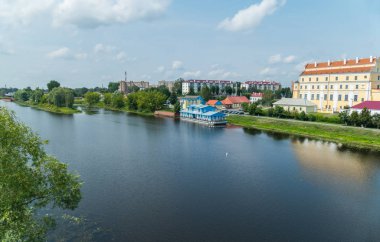 Güzel binalar ve yeşil yeşil alan fonunda büyük şeffaf mavi nehir