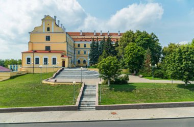 Şehir hattı ile yeşil çimenler ve ağaçlar yanında büyüyen yemyeşil bitki örtüsü ile bir güzel mimari konumu olan binanın girişine önde gelen adımları.