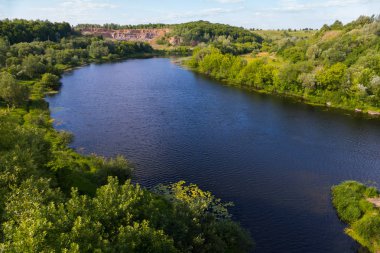 Büyüyen ağaçlar ve araştırma mineraller uzaktan görülür bir kesici ile yeşil bankalar arasında akan nehrin yukarıdan bir görünüm.