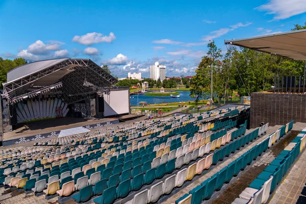 Sommerkonzertsaal mit leeren Tribünen unter freiem Himmel vor dem Hintergrund einer grünen Parkzone mit See — Stockfoto