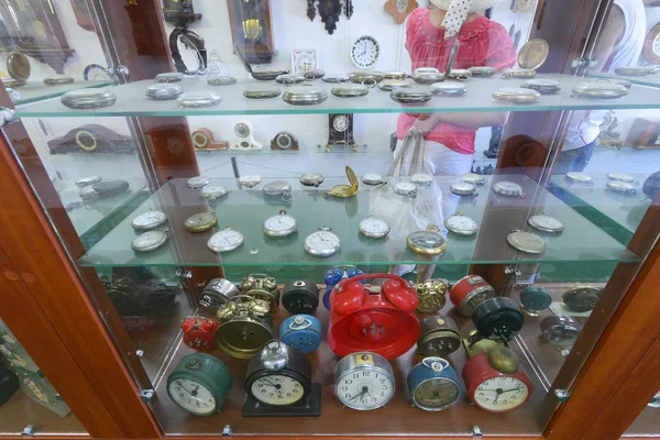 Koleksi besar dari berbagai jam alarm dan jam saku di jendela di belakang kaca di dalam museum . — Stok Foto