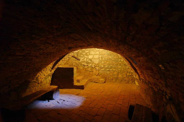 Rummet med ett tak i form av en båge med bänkar tillverkade av två träklossar och en bräda under en vägg som kantas av sten. — Stockfoto