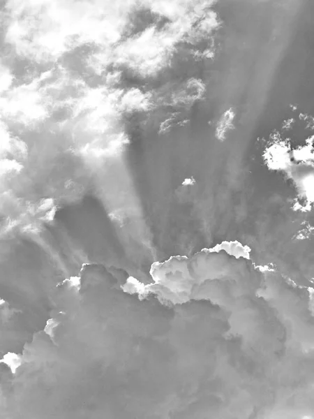 A photo of the sky in the clouds through which the suns rays break through in a black and white filter — Stock Photo, Image