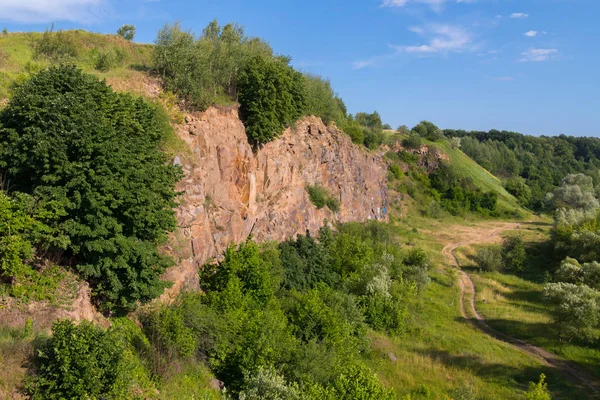 Klinkergolv steniga kullar med en grusväg vid foten av den blå himlen — Stockfoto