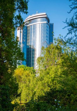 Yansıtılmış windows ve güneş ışınlarını yansıtan bir kaplama ile parlak bir gökdelen