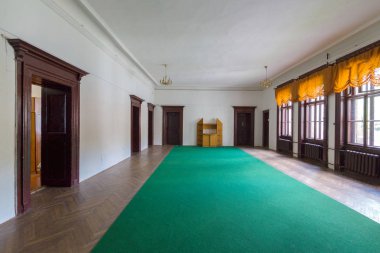 Geniş bir koridor bir yeşil yol ve parke birçok kapı ile diğer odalar ve büyük pencereler sokağa conduced.