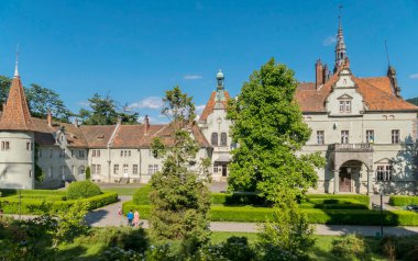 Yürüyüşler ve parlak çiçek çiçek yatak üzerinde güzel çim yolları ile lüks bir yeşil avlu ile güzel bir konuma bir antik kale.