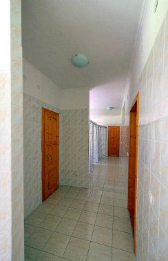 bir karo soyunma odasında kahverengi ahşap bir kapı ile çevrili bir ışık koridor