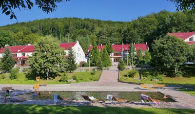 Bir dinlenme şezlong üzerinde olması ve bir otelde karmaşık bir arka plan üzerinde bir havuzda boğulmuş turist