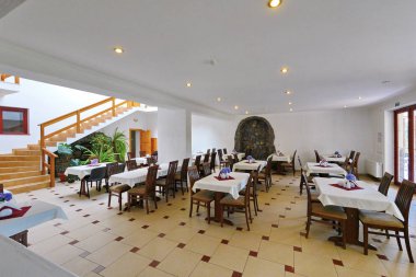 beyaz masa örtüsü ile kaplı ahşap masa ile modern yenileme ile restoran salonu