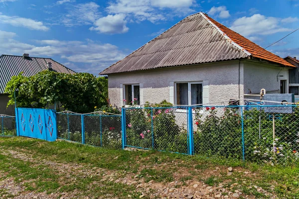 Casa rural cubierta de pizarra con una hermosa cama de flores cerca de él — Foto de Stock