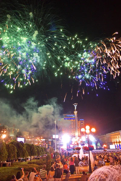 A huge number of people are watching fireworks in the main square of the city